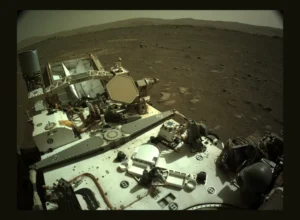 Image of Mars from NASA's Mars Perseverance rover showing the rover in the foreground and mountains in the background.