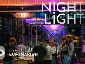 A group of adults interacting with museum exhibits. Text overlay reads: Night Light.